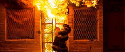 A firefighter uses a saw to open a metal gate while fighting a fire in a convenience store and residence during clashes after the funeral of Freddie Gray in Baltimore, Maryland in the early morning hours of April 28, 2015. Baltimore erupted in violence as hundreds of rioters looted stores, burned buildings and injured at least 15 police officers following the funeral of Gray, a 25-year-old black man who died after he was injured in police custody. REUTERS/Eric Thayer TPX IMAGES OF THE DAY