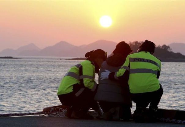 A relative, center, of a passenger aboard the sunken Sewol ferry is consoled by police officers as she awaits news on her missing loved one at a port in Jindo, South Korea, Wednesday, April 30, 2014. Two weeks after the ferry sank off South Korea's southern cost, divers have recovered over 200 bodies from the wreckage, but they fought strong currents and floating debris inside the ship Wednesday as they searched for 90 passengers still missing. (AP Photo/Yonhap) KOREA OUT (File: South Korea Ship Sinking.JPEG-0f735.jpg )