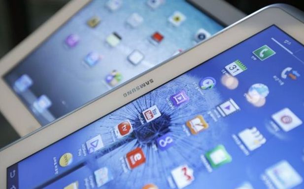 Samsung Electronics' Galaxy Tab (front) and Apple's iPad are seen in Seoul, in this May 13, 2013 file picture illustration. A U.S. jury on May 2, 2014, ordered Samsung Electronics Co Ltd to pay $119.6 million to Apple Inc, after it found the South Korean smartphone maker had infringed two Apple patents. During the month-long trial in a San Jose, California, federal court, Apple accused Samsung of violating patents on smartphone features including universal search, while Samsung denied wrongdoing. REUTERS/Kim Hong-Ji/Files (SOUTH KOREA - Tags: BUSINESS SCIENCE TECHNOLOGY) (File: 2014-05-03T004124Z_677552774_GM1EA530O2Q01_RTRMADP_3_APPLE-SAMSUNG-ELEC-DAMAGES.JPG )