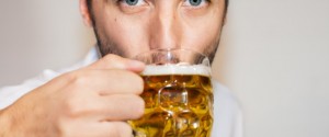 Closeup portrait of blue eyed man drinking beer