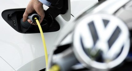 An employee plugs a charger to an E-Golf at a station at the plant of German carmaker Volkswagen in Wolfsburg, Germany May 20, 2016. REUTERS/Fabian Bimmer