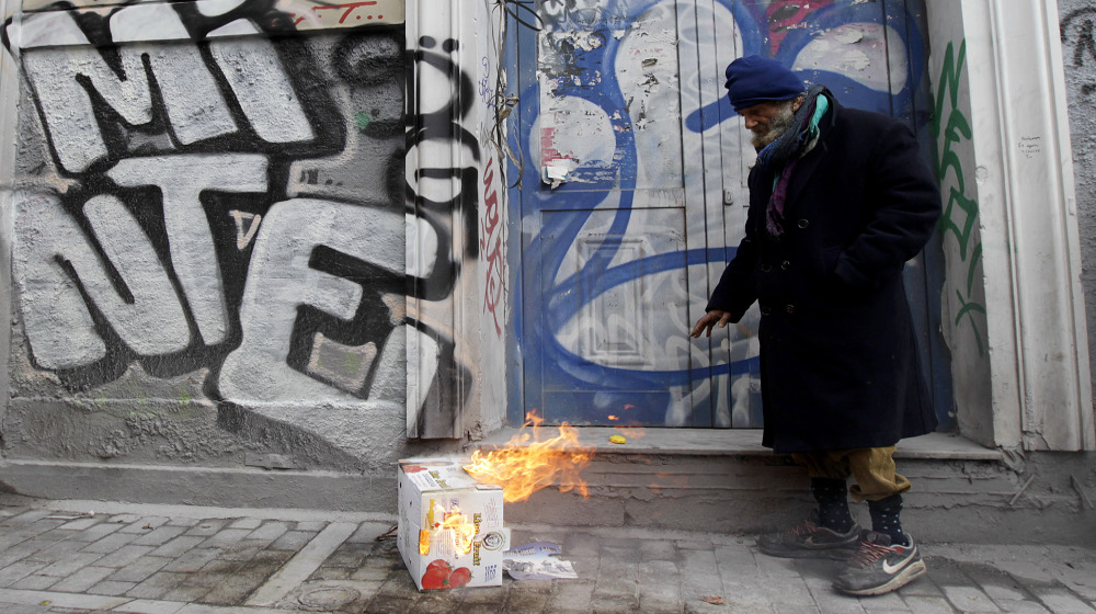 Αστεγος έχει βάλει φωτιά σε χαρτόκουτα για να ζεσταθεί, Αθήνα Τετάρτη 18 Φεβρουαρίου 2015. Η θερμοκρασία στην Αθήνα είναι 3 βαθμοί Κελσίου. Σύμφωνα με έρευνα του 2012 οι άστεγοι στην Αθήνα ήταν περίπου 9000 και στην πλειοψηφία τους δεν ήταν άστεγοι πριν την οικονομική κρίση.  ΑΠΕ-ΜΠΕ/ΑΠΕ-ΜΠΕ/ΟΡΕΣΤΗΣ ΠΑΝΑΓΙΩΤΟΥ