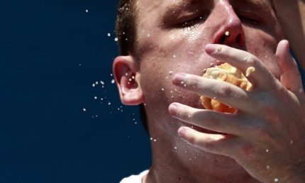 Joey Chestnut competes in the 2012 Nathan's Famous Fourth of July International Eating Contest at Coney Island in the Brooklyn borough of New York July 4, 2012. Chestnut ate a record-tying 68 hot dogs to take the crown. REUTERS/Eric Thayer (UNITED STATES - Tags: FOOD ENTERTAINMENT SOCIETY TPX IMAGES OF THE DAY HEADSHOT) - RTR34LK2